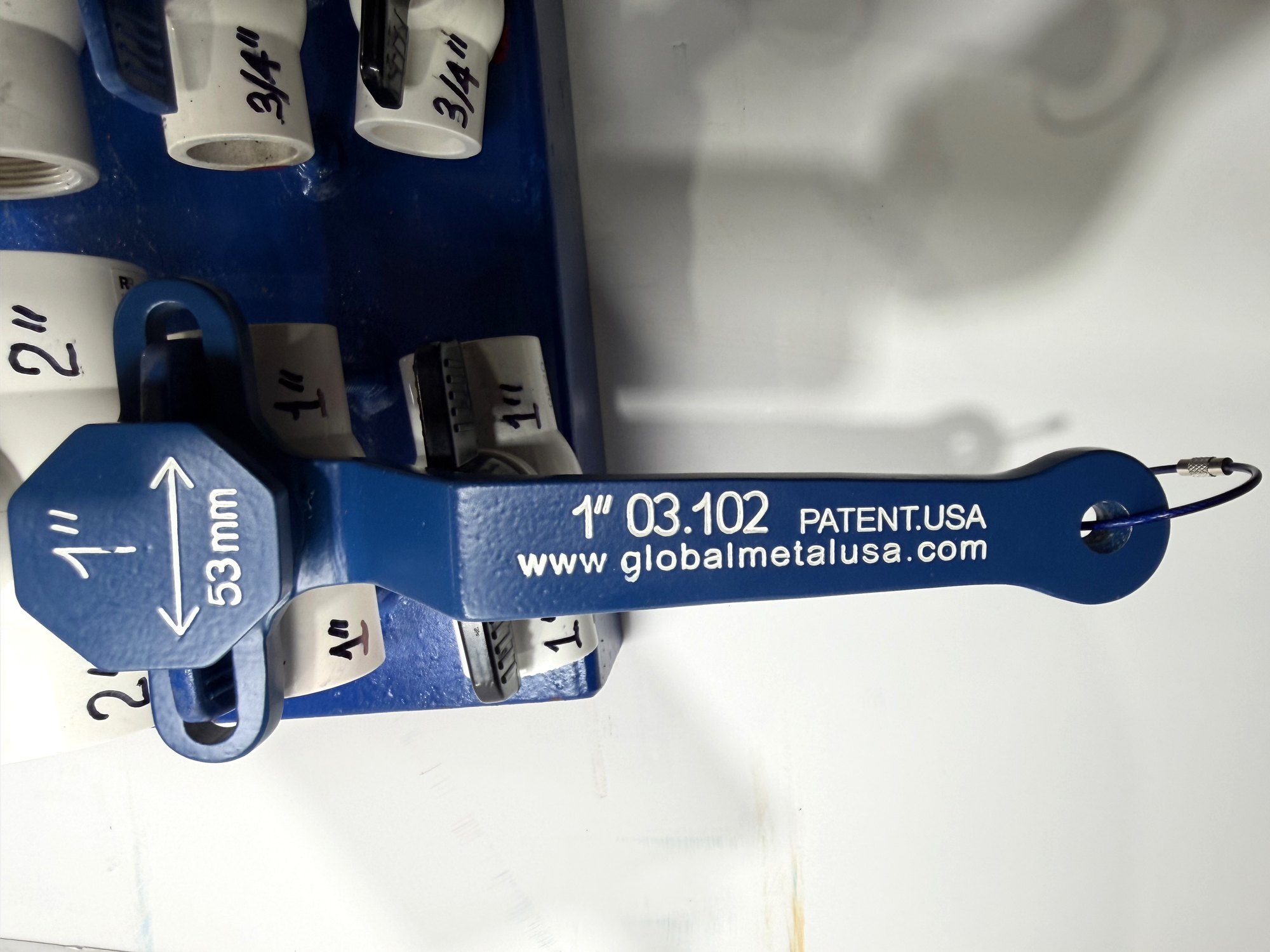 1-inch PVC ball valve frame wrench fitted on a 1-inch valve beside the 2-inch valve on a blue display board, item 03-102