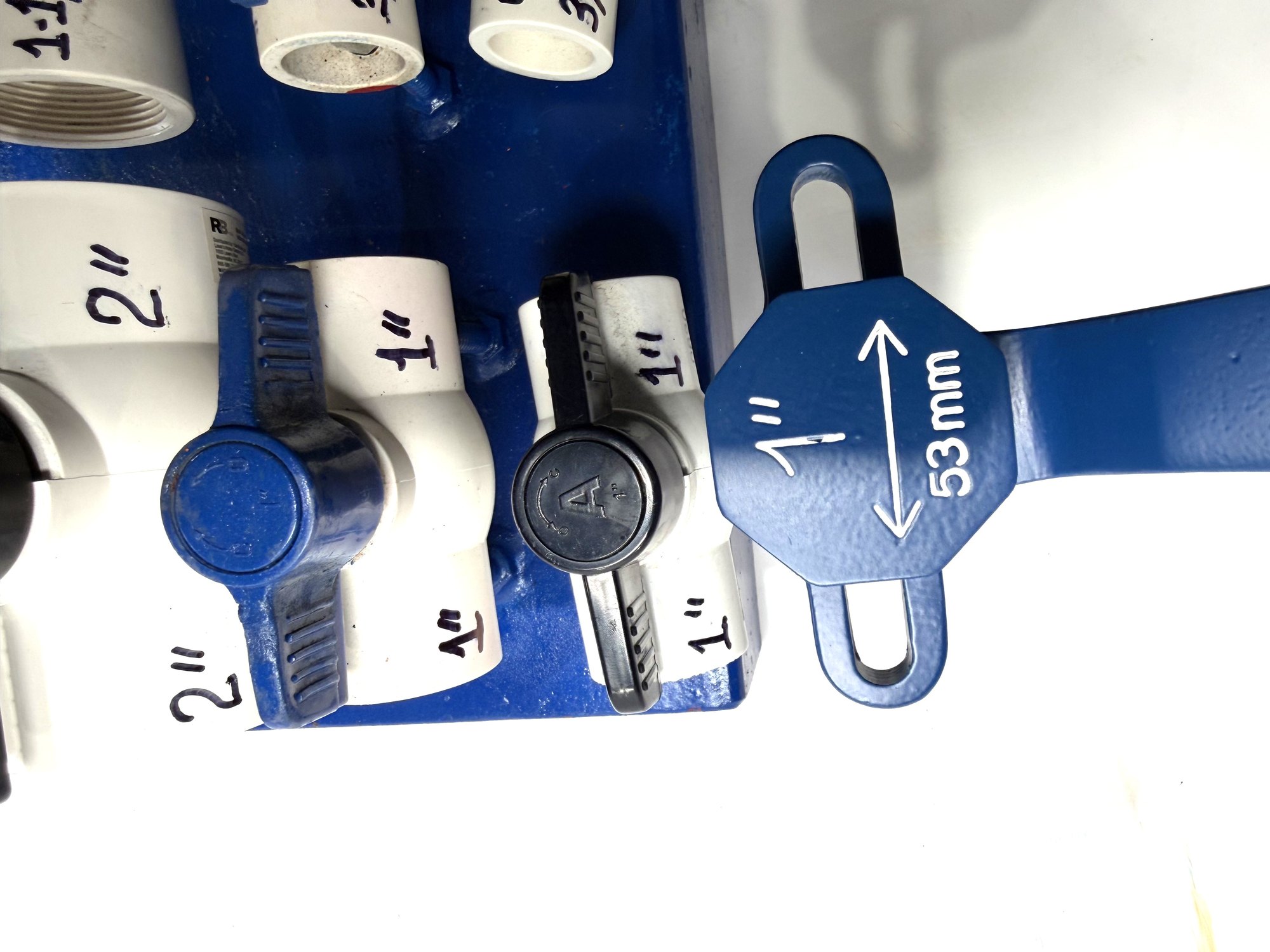 1-inch PVC ball valve frame wrench head next to 1-inch valves, wider view taking in the top row of the board, item 03-102