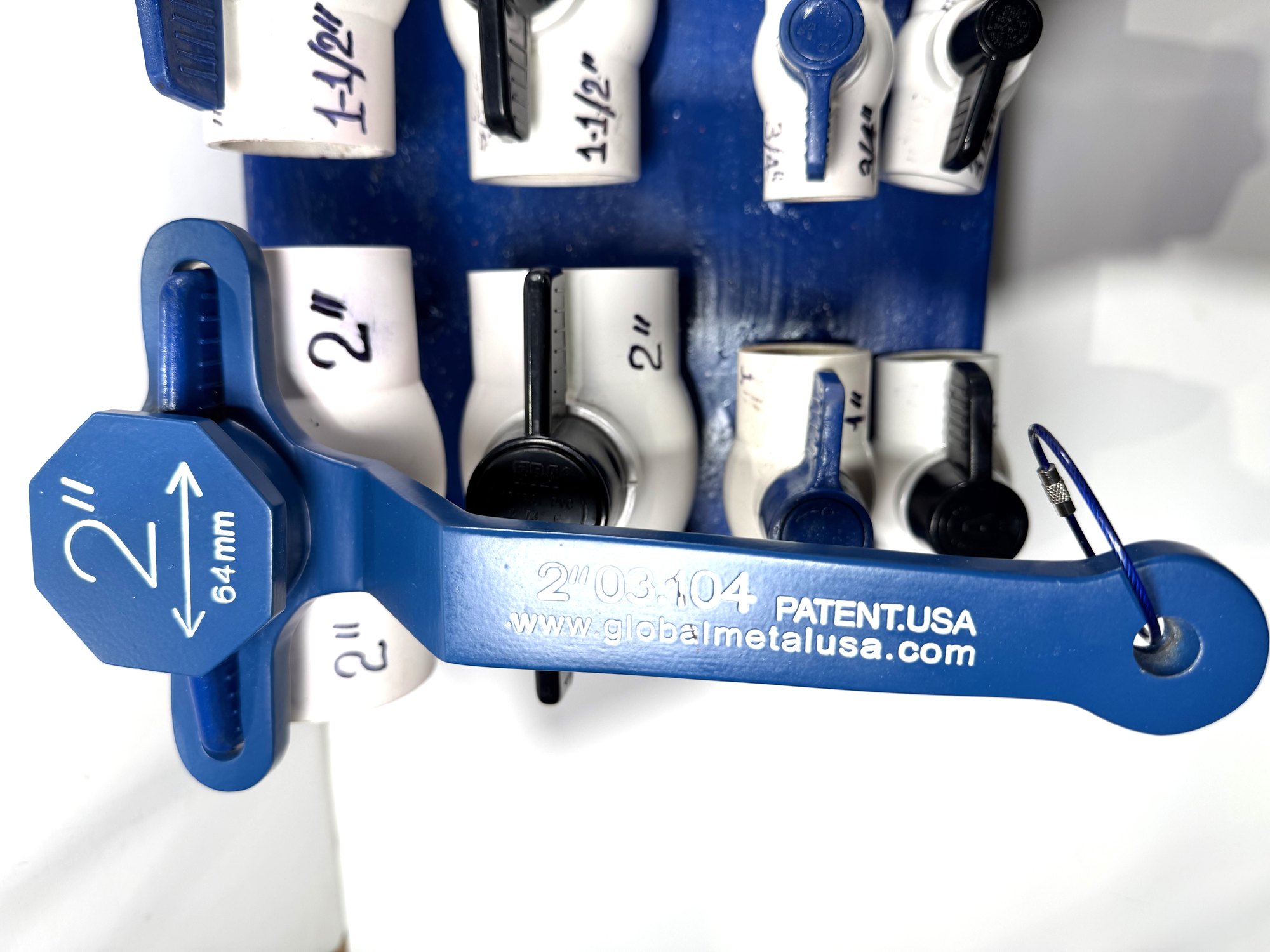 2-inch PVC ball valve frame wrench seated on a 2" PVC ball valve, its blue lever through both arm slots, item 03-104